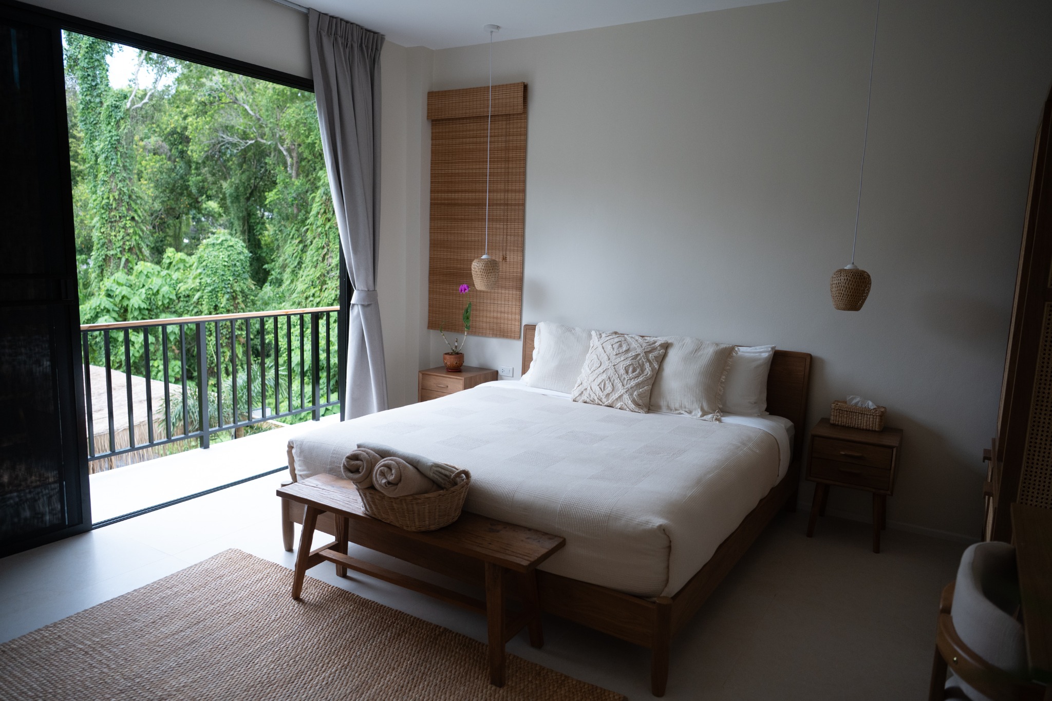 Balcony Junior Suite bedroom opening onto a tropical view