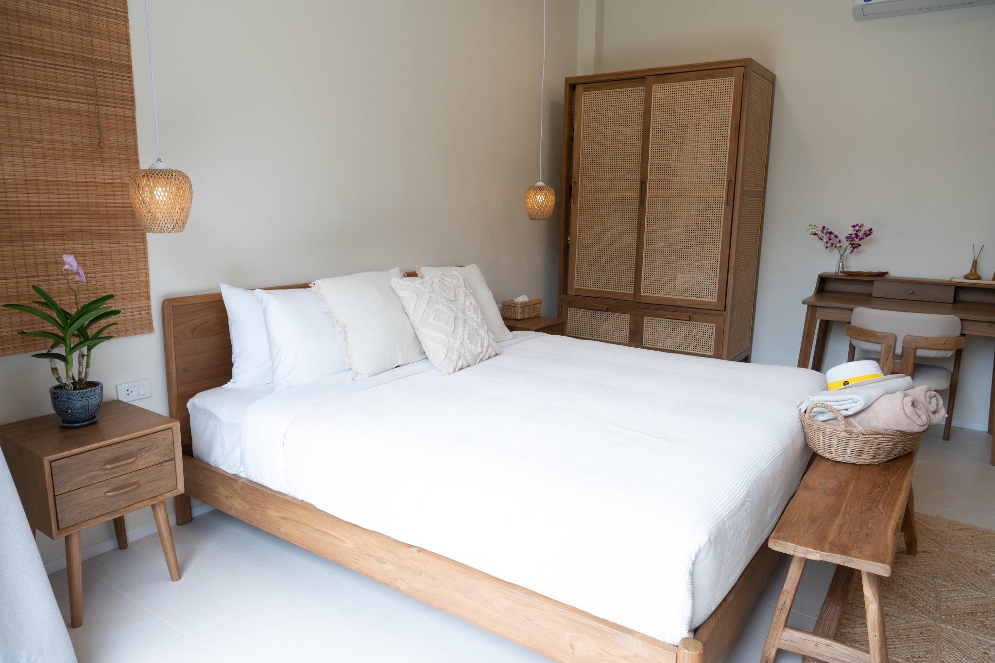 Junior Suite king bed with natural wood and rattan furniture